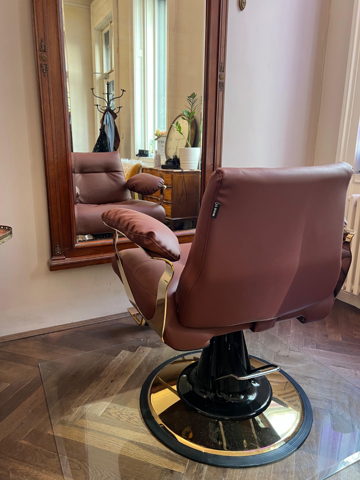 Friseurstuhl vor einem großen Holzspiegel