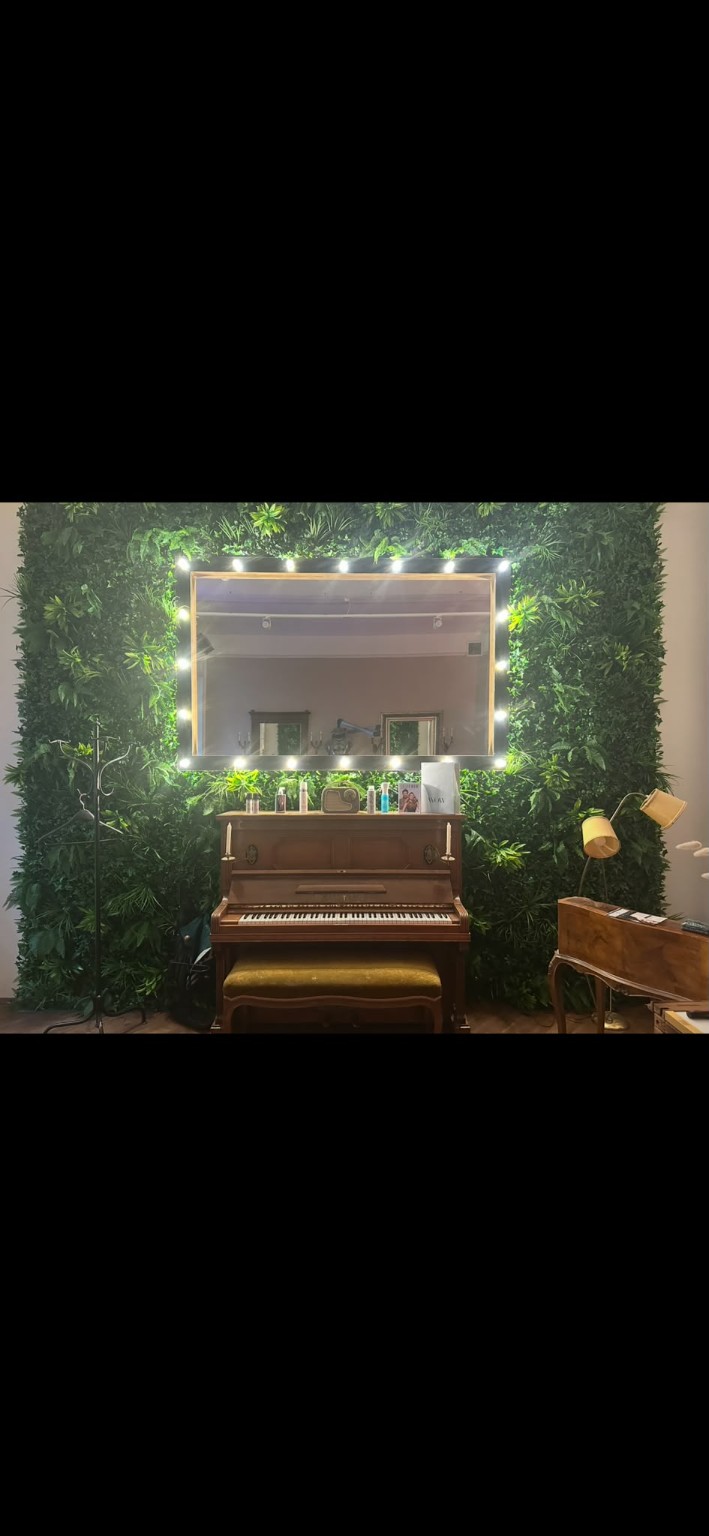 Bepflanzte Wand mit Spiegel und Klavier im MØNDM Salon